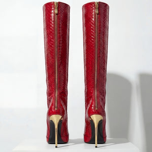 Red knee-high boots with gold zippers and soles on a white background