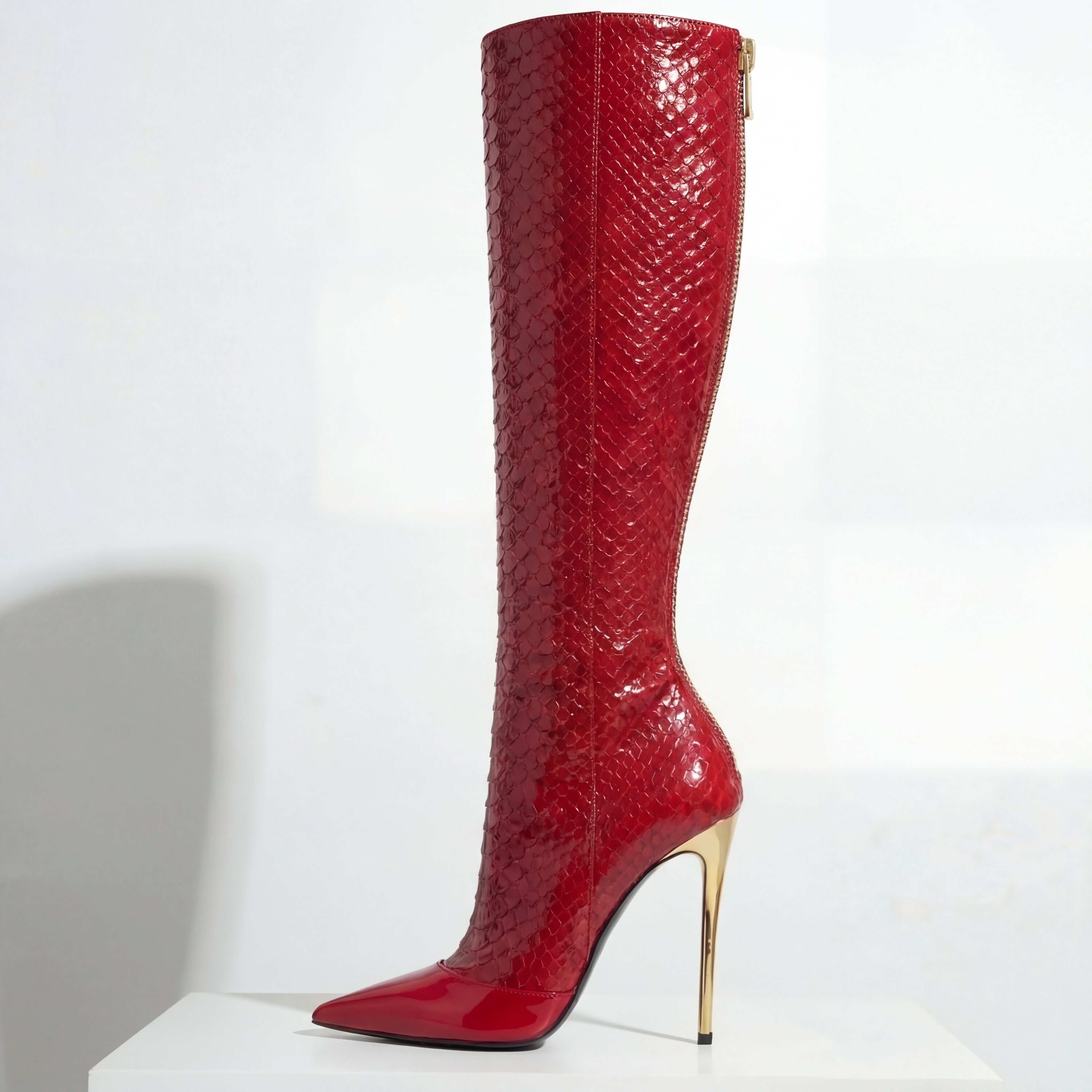 Red knee-high boot with high heel on a white background