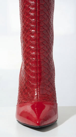 Red patent leather boot with snake skin pattern on a white background